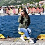 Erin sits along Bergen's harbor in front of a row of colorful buildings