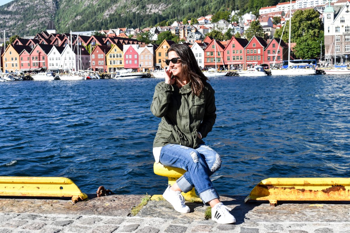 Erin sits along Bergen's harbor in front of a row of colorful buildings