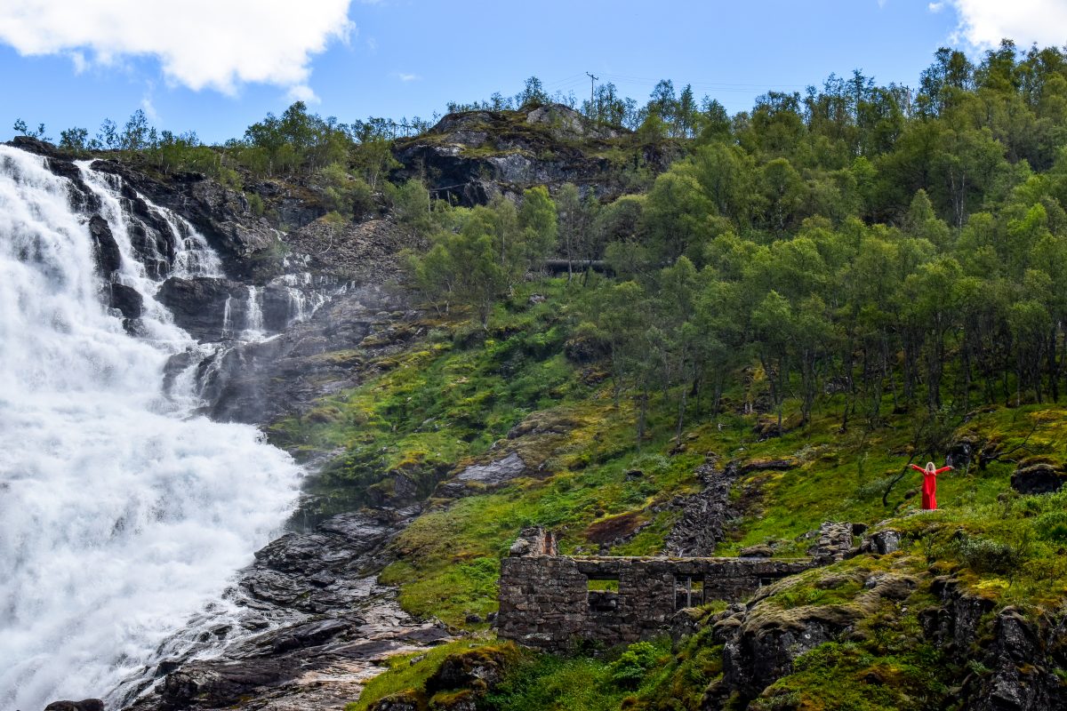 A dancing Huldra appears next to a waterfall on the Norway in a Nutshell tour