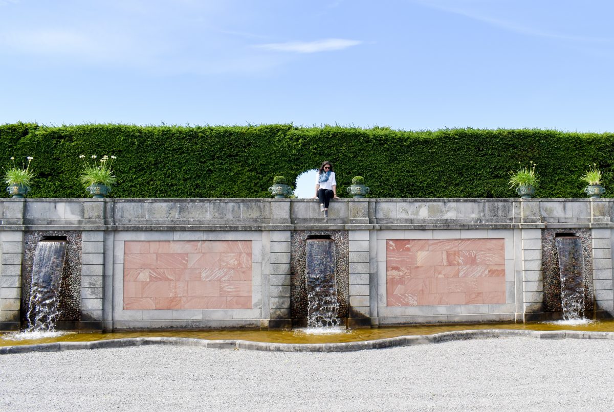 Erin sits atop a stone fountain in the Drottningholm Palace gardens in Sweden