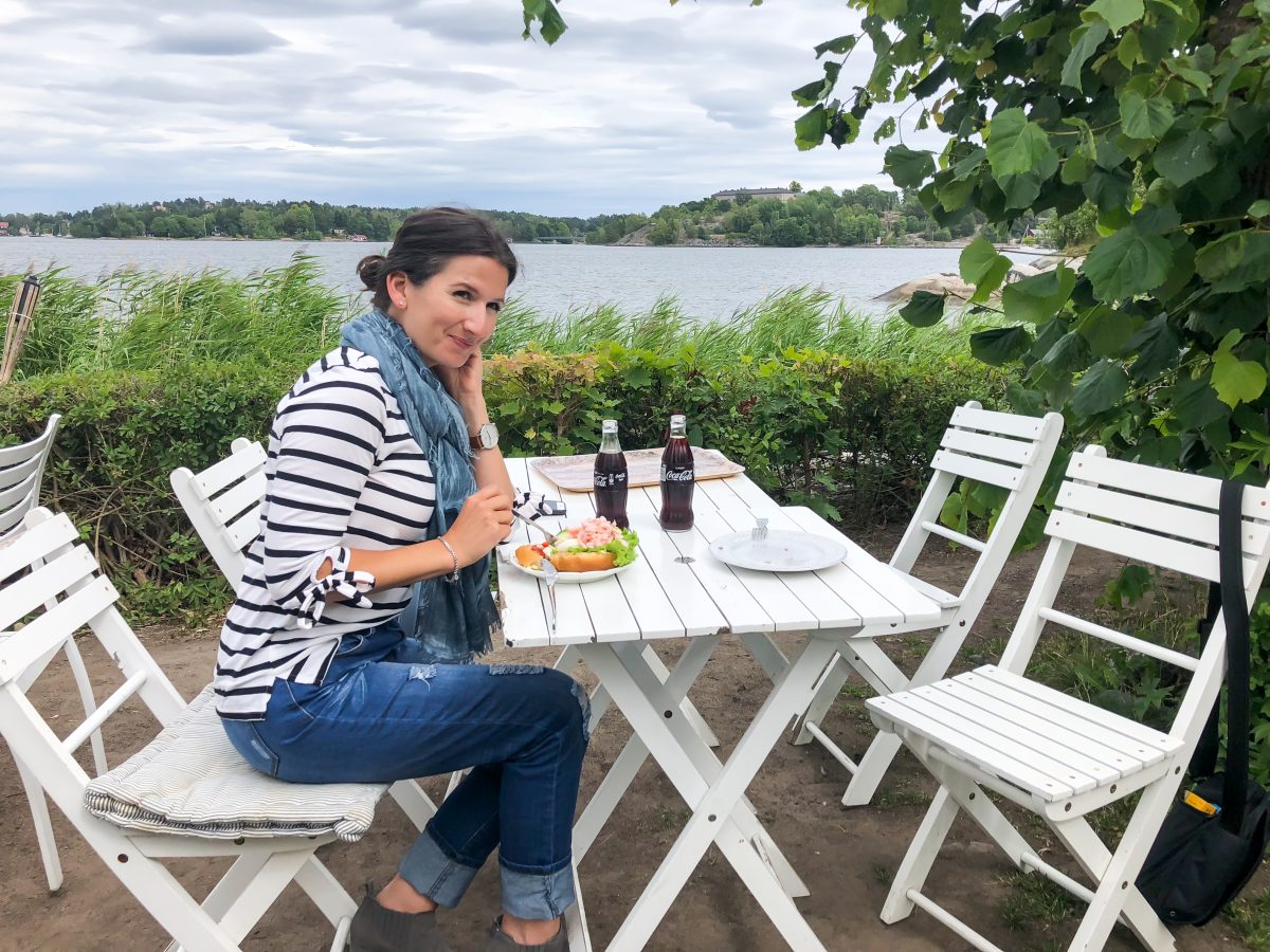 Erin enjoys a seaside lunch in Vaxholm, Sweden wearing a nautical striped tee.