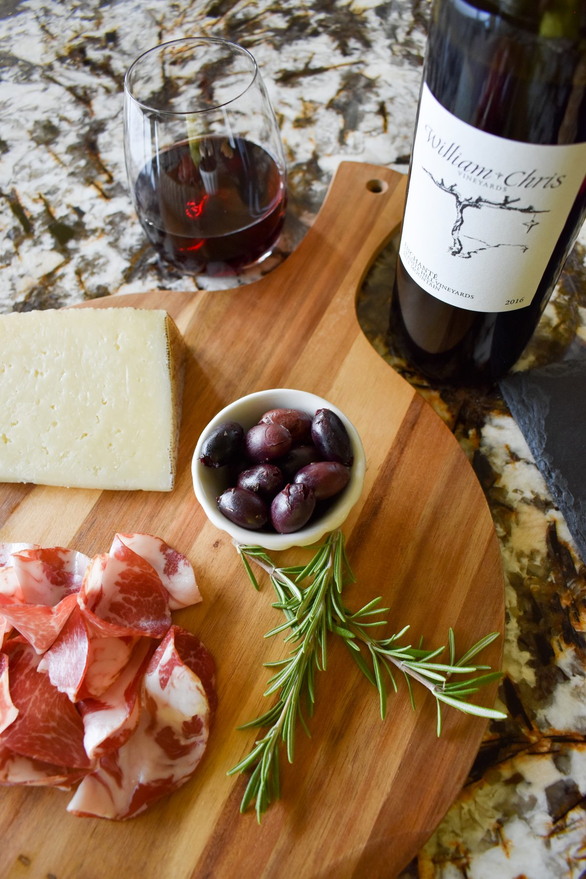 Enchanté red wine from William Chris Vineyards with a charcuterie board of coppa, olives, and manchego cheese.