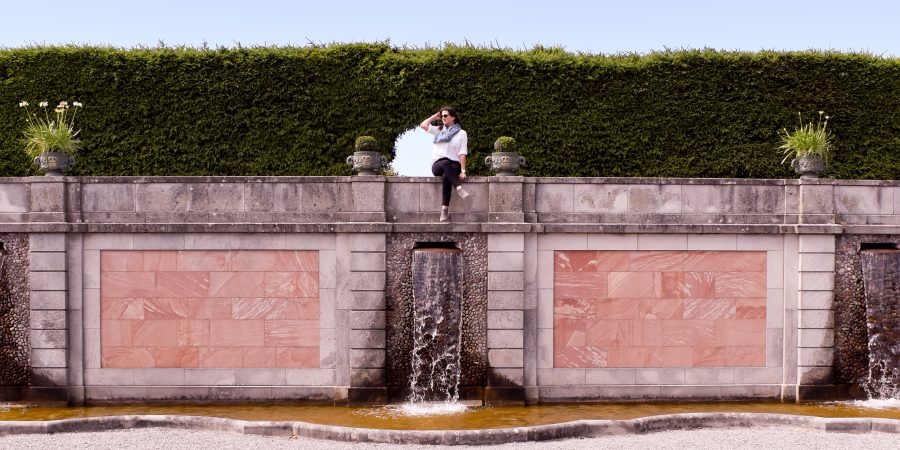 Erin sits on the fountain wall in the gardens of Drottningholm Palace