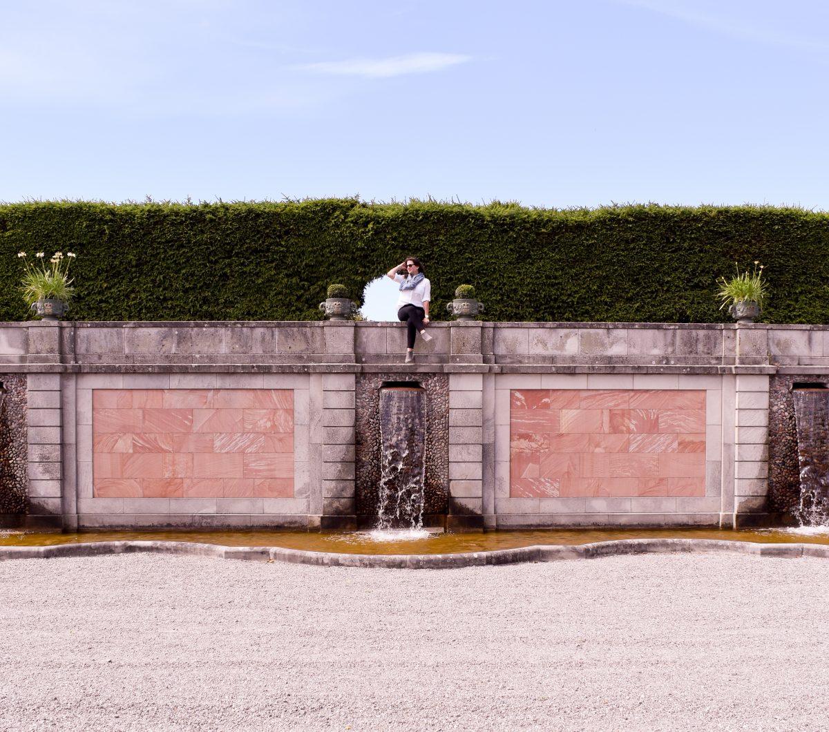 Erin sits on the fountain wall in the gardens of Drottningholm Palace